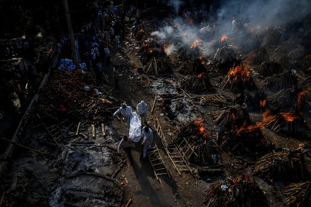 周一，在新德里的一个火葬场，新冠病毒罹难者被集体火化。