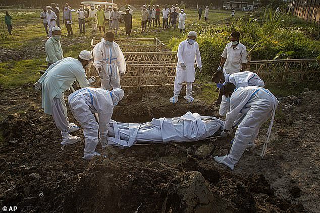 42221944-9514967-Pictured_Municipal_workers_prepare_to_bury_the_body_of_a_person_-a-4_1619620096585.jpg,0