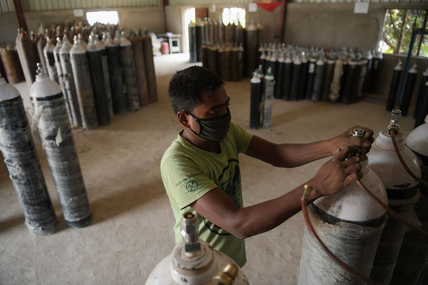 工人在印度阿加尔塔拉填充氧气罐。（新华社）