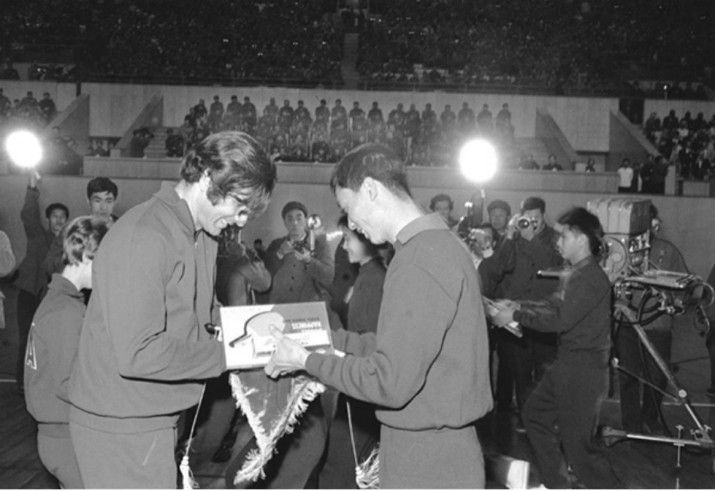 1971年4月13日，中美两国乒乓球运动员在北京首都体育馆友谊比赛间隙互赠礼品。（新华社）