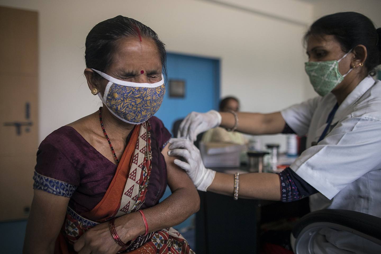 2021年4月22日，新德里一名婦人接受新冠疫苗注射。印度年初時疫情曾受控，更可參與向外供應疫苗，但現時國內疫情大爆發，為解決內憂可能會影響其疫苗出口情況，進而影響全球疫苗供應。（Anindito Mukherjee／Getty Images）