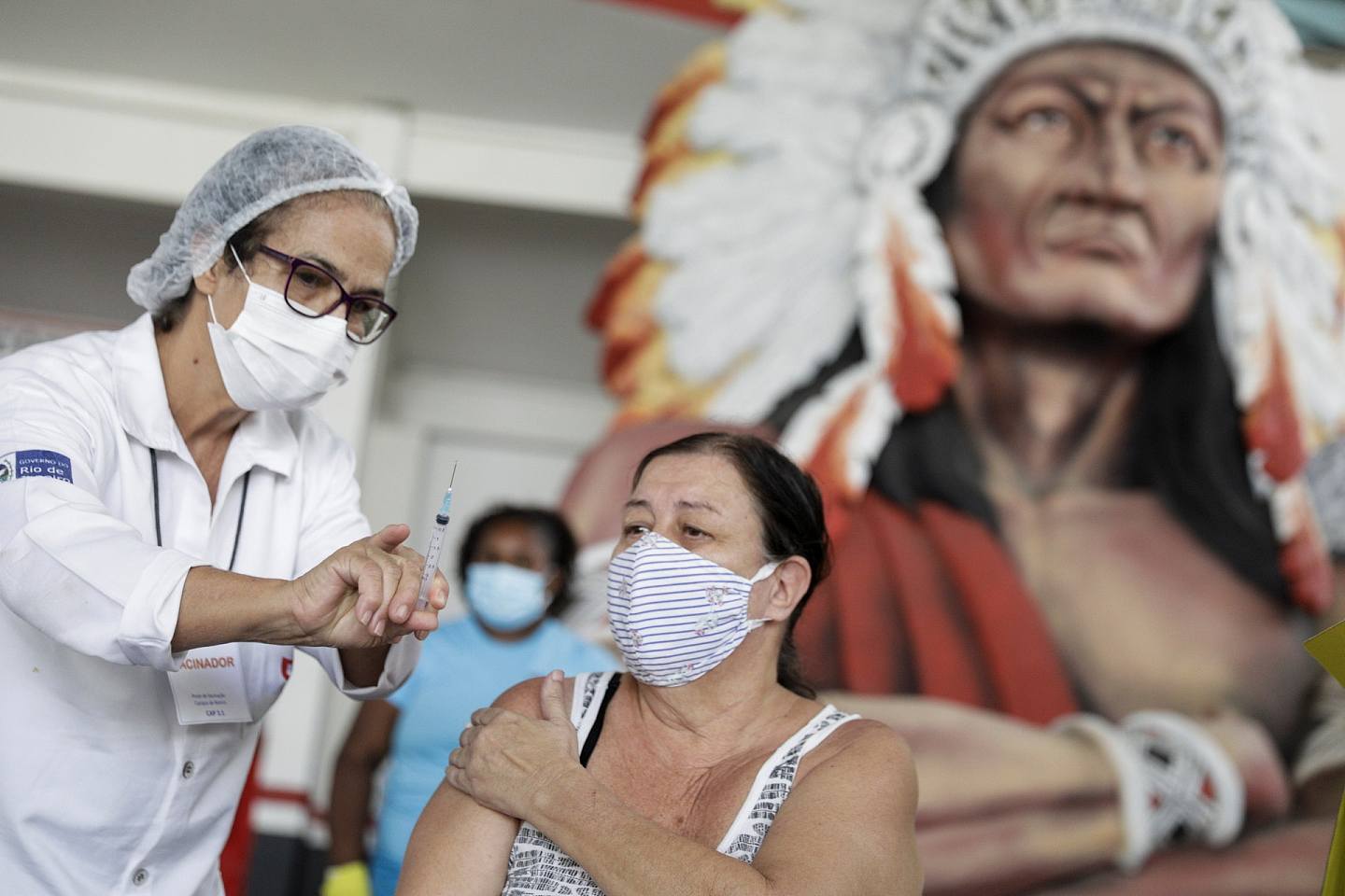 巴西新冠肺炎疫情：图为4月8日巴西的医疗保健工作人员在里约热内卢为一名女子施打科兴疫苗后，向她展示针筒。 （Reuters）