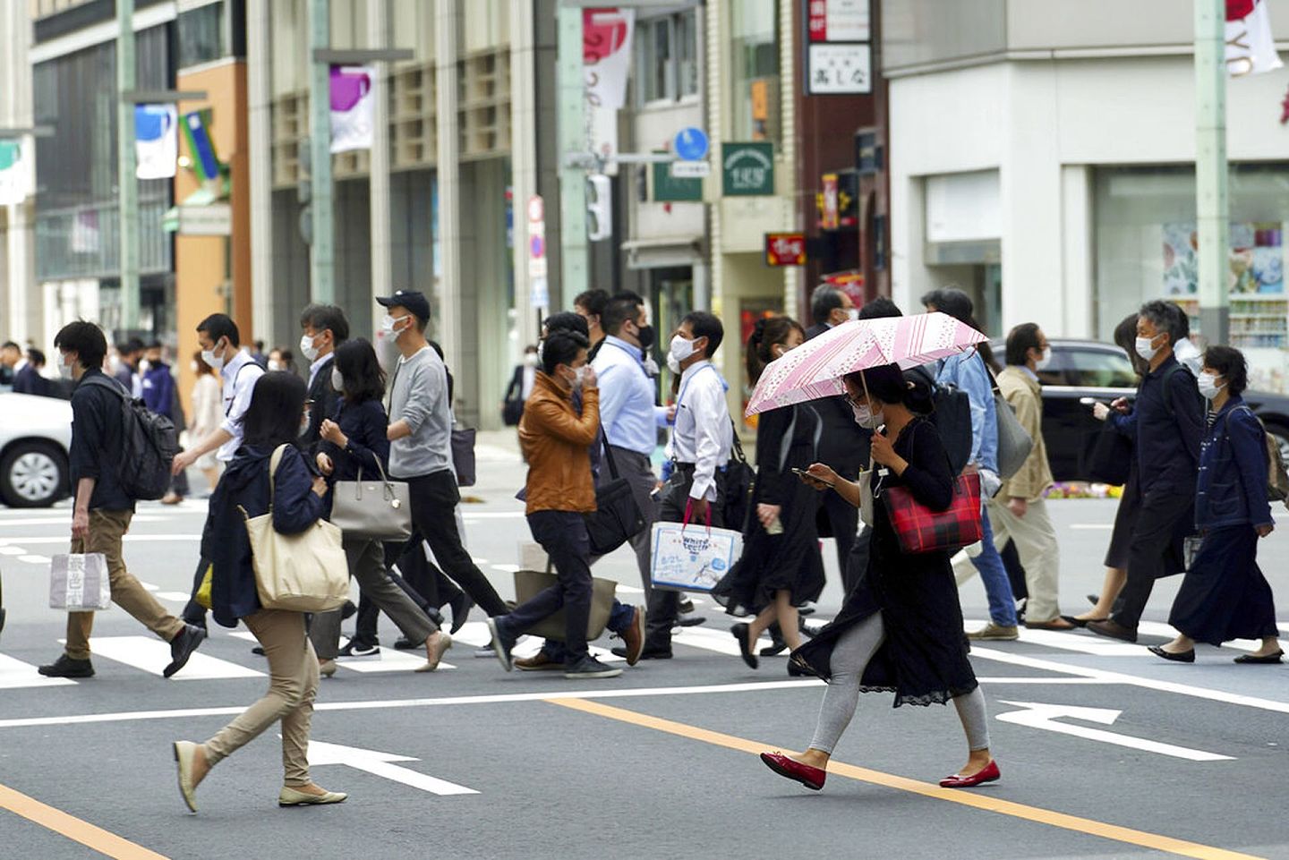 日本新冠肺炎疫情：图为5月12日，东京街头的途人在横过马路。（AP）