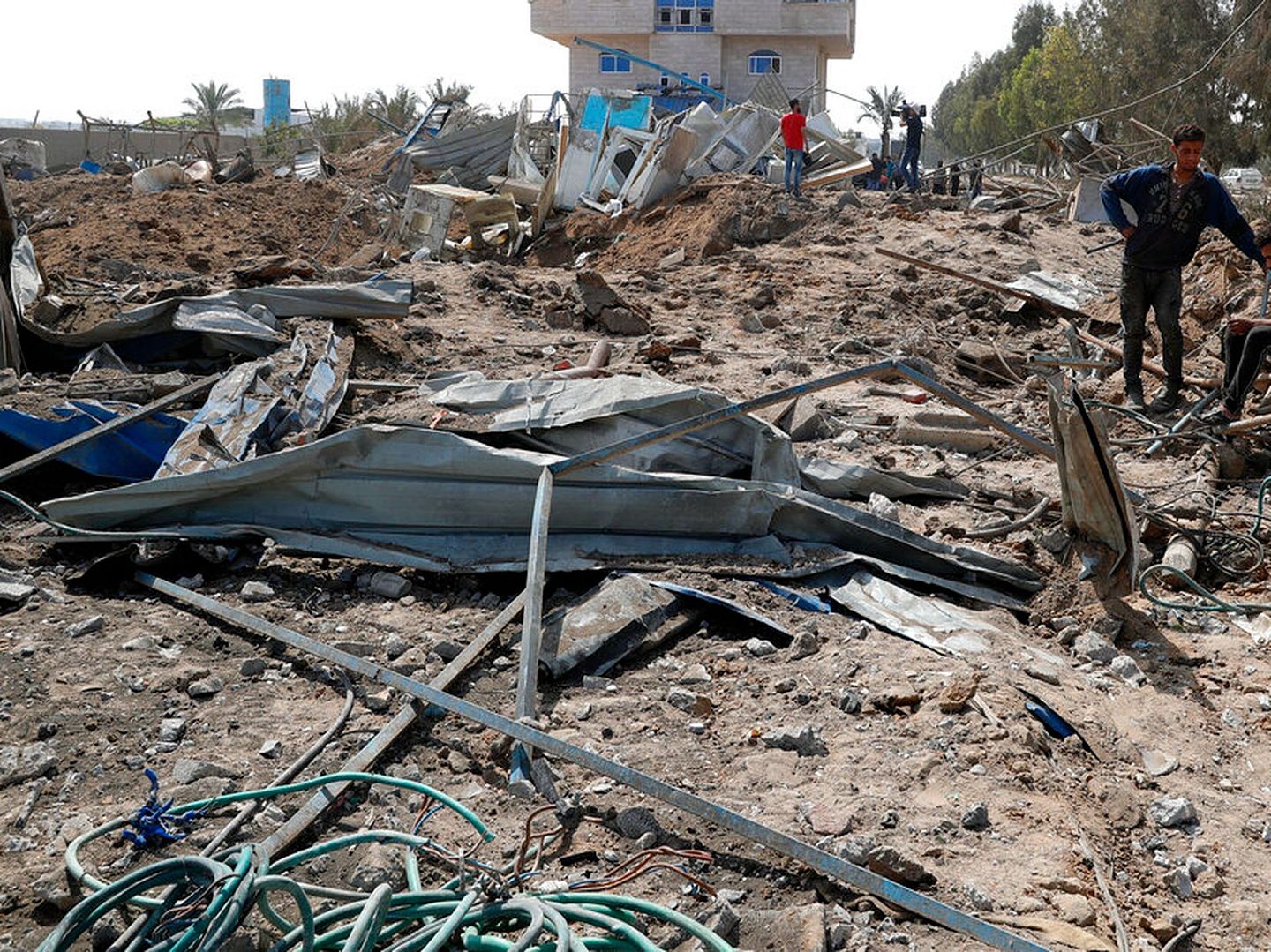 巴勒斯坦人在加沙检察以色列空袭摧毁的制冰厂和机械车库的废墟。（AP）