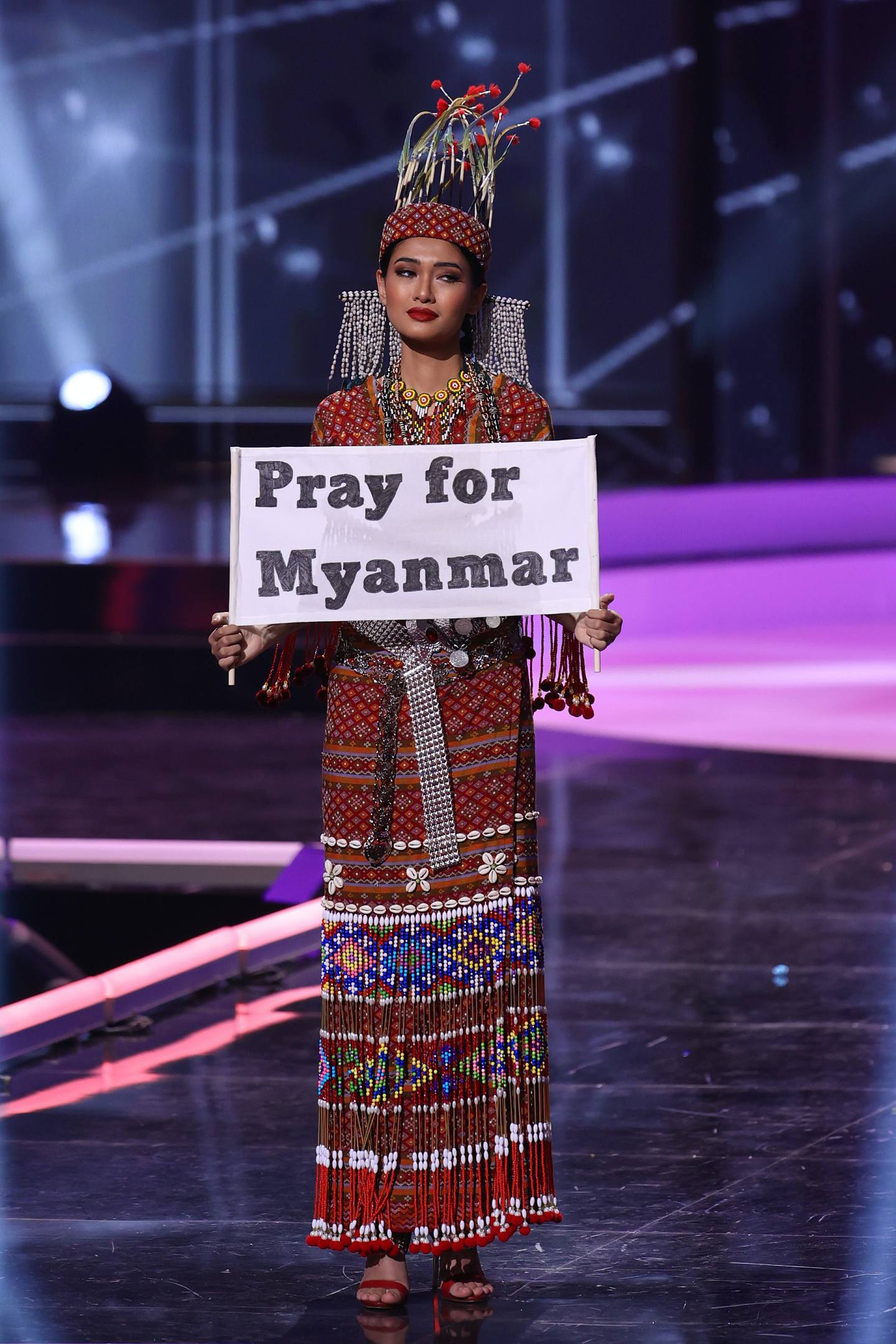 图为2021年5月13日，缅甸环球小姐Ma Thuzar Wint Lwin于美国出席环球小姐选美大赛的民族服装环节。 她于台前展示出写有「为缅甸祷告」的标语。 （Getty Images）