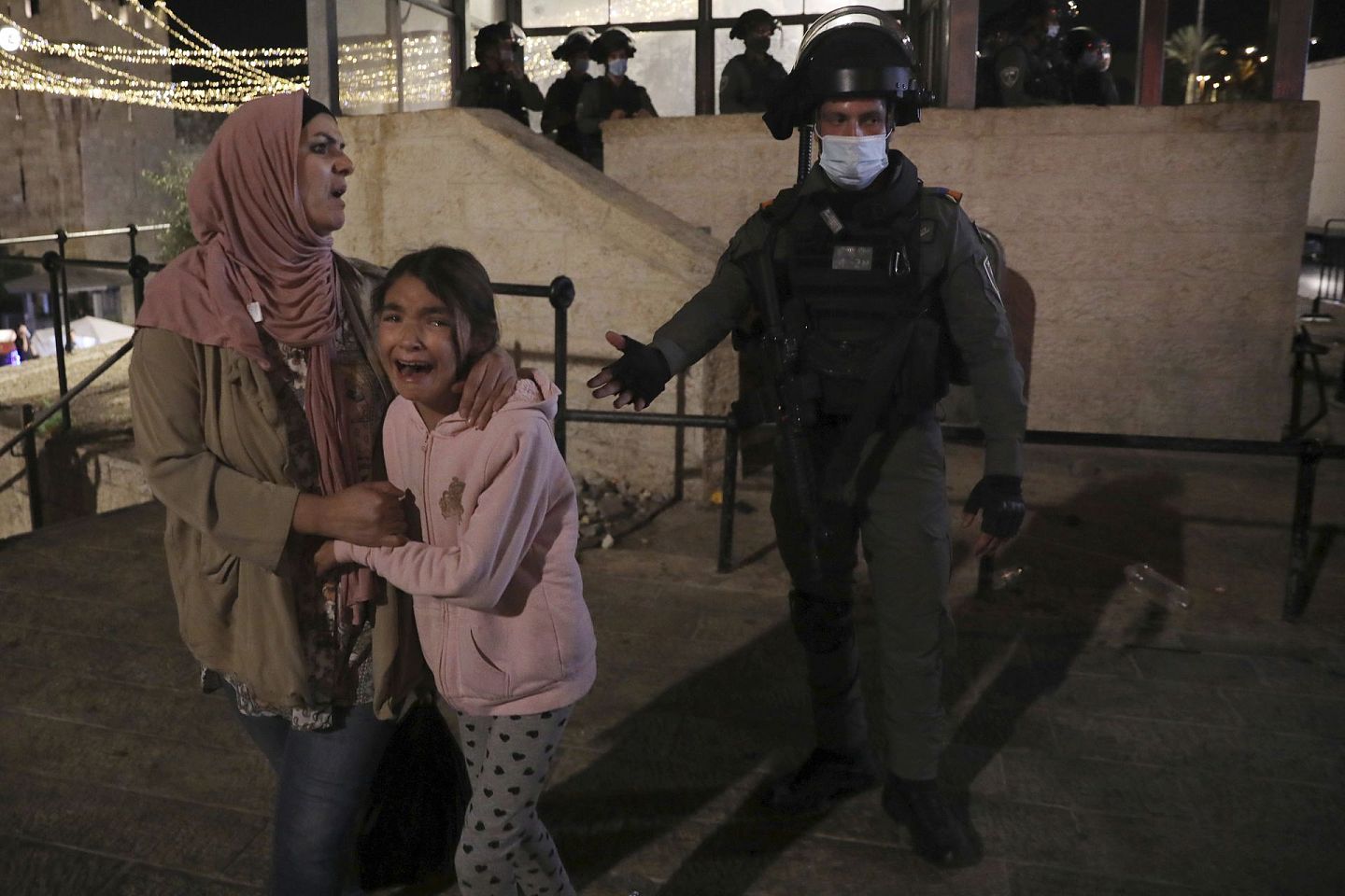 2021年5月11日，在耶路撒冷的冲突中，一名以色列警察驱赶一名巴勒斯坦妇女和她的女儿。（AP）
