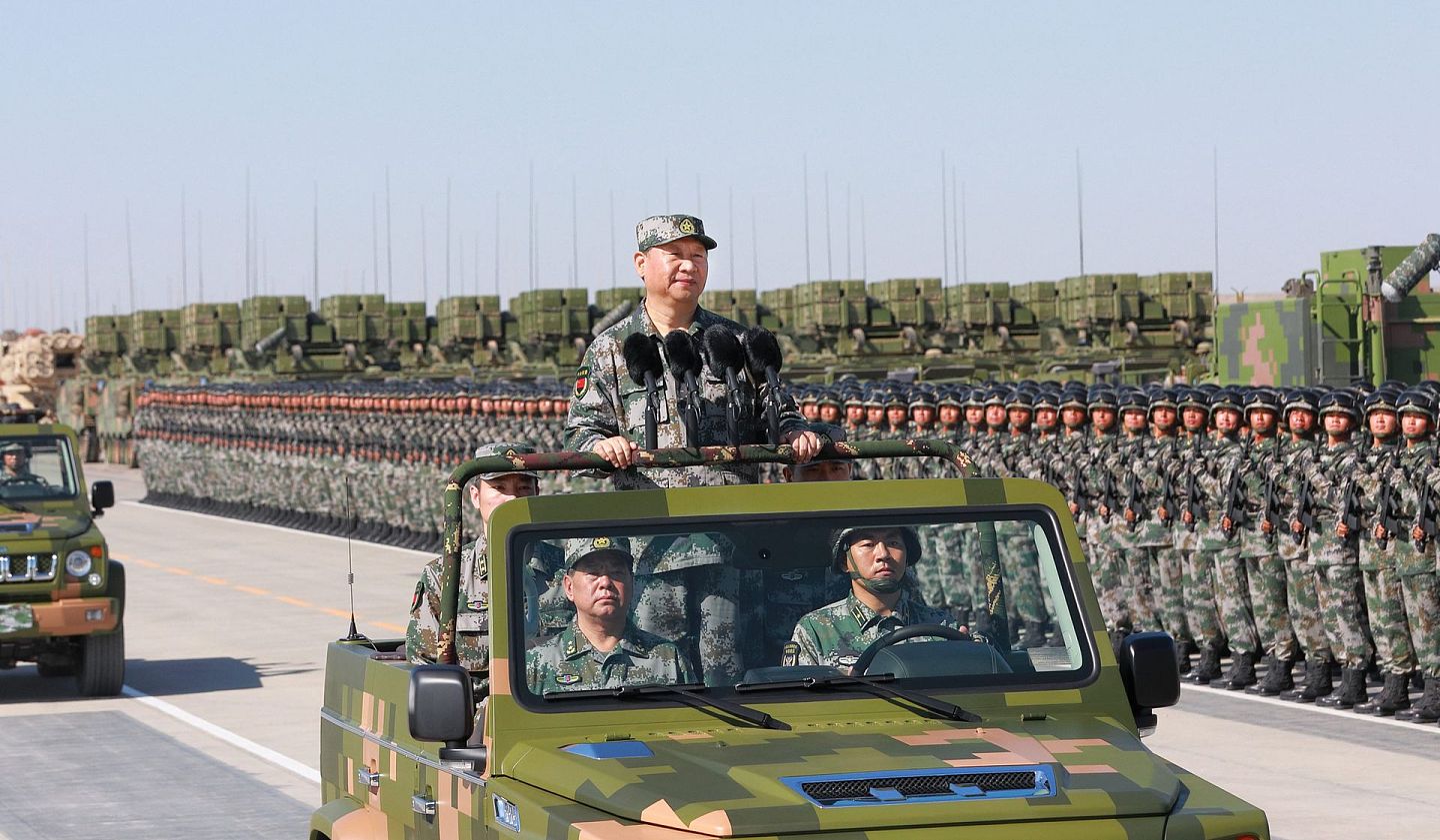 2017年7月30日，解放军建军90周年前夕，在内蒙古朱日和基地，习近平身穿绿色迷彩服，登上越野车，检阅野战部队。（新华社）