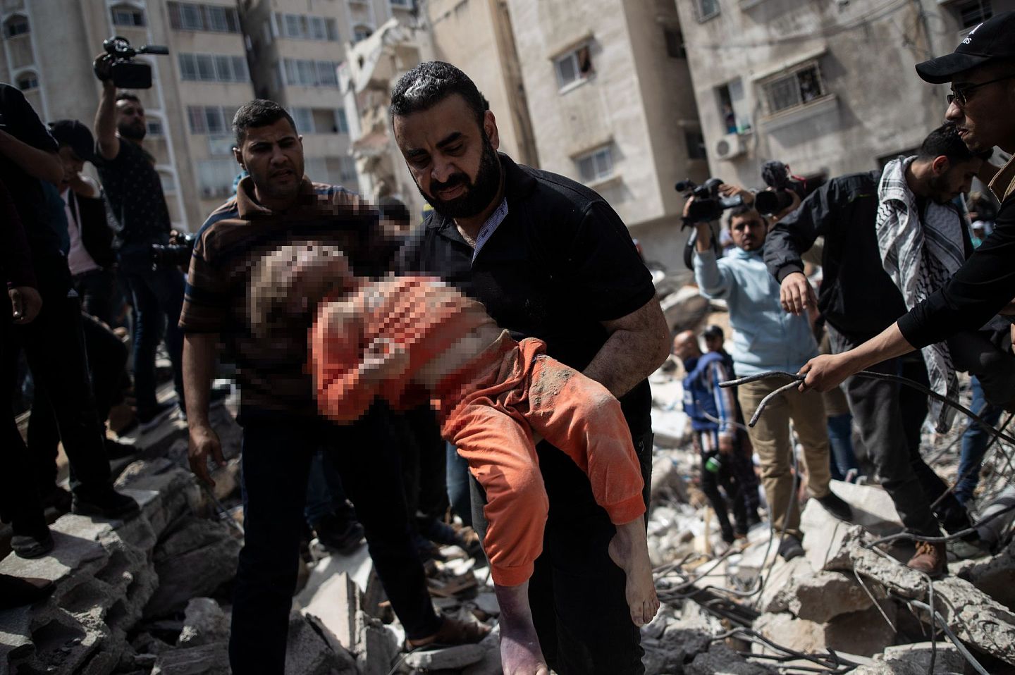 5月16日，在以色列空袭加沙后，一名巴勒斯坦男子抱着一名从废墟中被救出的死去的孩子。（AP）