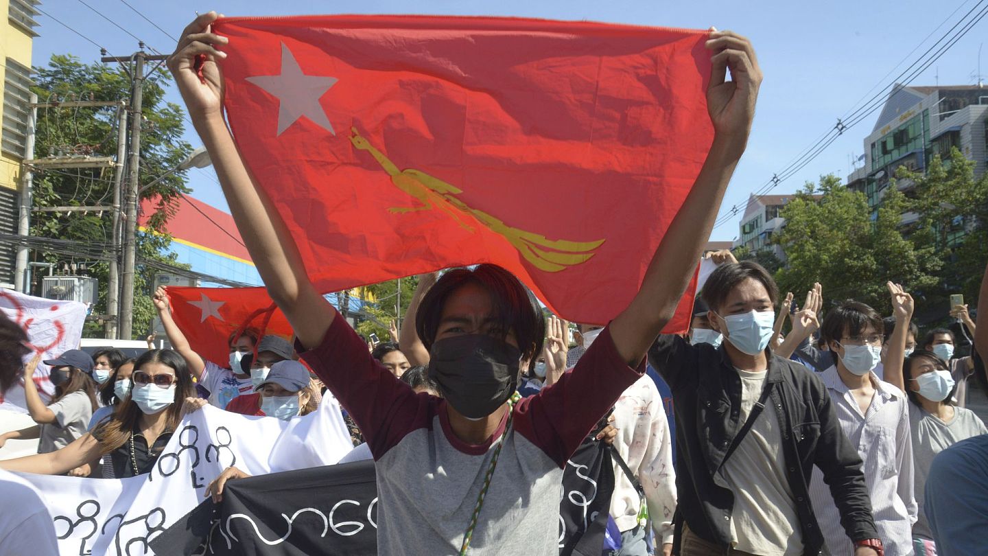 缅甸局势：图为5月14日，缅甸仰光反政变示威者出示全国民主联盟的旗帜。（AP）