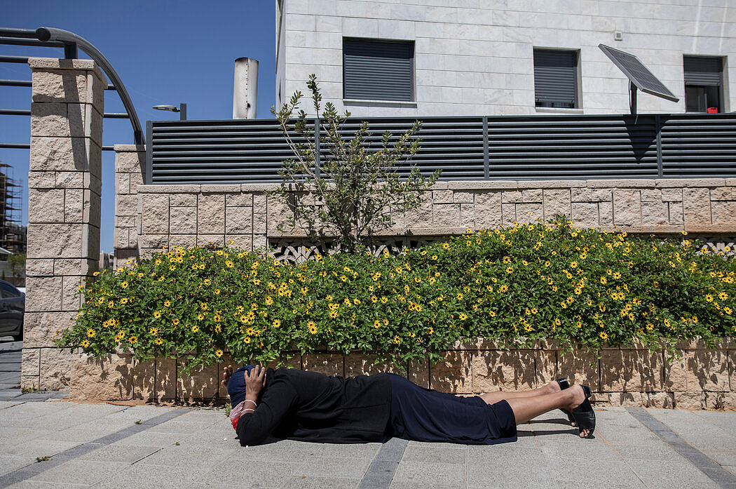 周二在阿什基伦市，一名以色列女子躲避加沙射来的火箭弹。