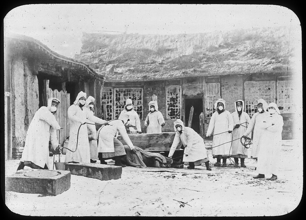 1911年，在中国长春，卫生工作者准备埋葬一具鼠疫受害者的尸体。