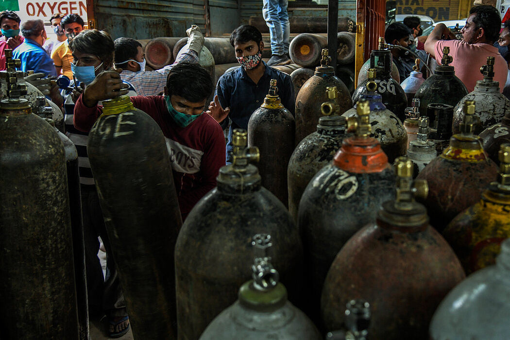上周，工人们在德里一家氧气补充店储存钢瓶。4月底和5月初，病毒激增使一些医院面临严重的救生氧气短缺。