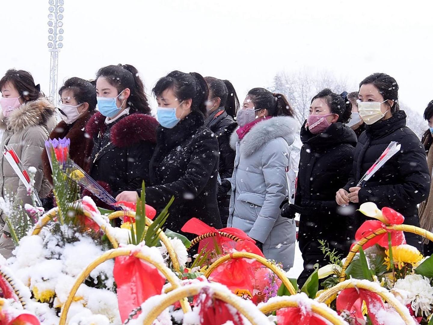 全球新冠肺炎疫情从2020年初爆发至今，朝鲜境内确诊人数据称为零。图为2020年2月16日，平壤民众前往已故领导人金日成和金正日的雕像前献花，其中不少人佩戴了口罩。（AFP）