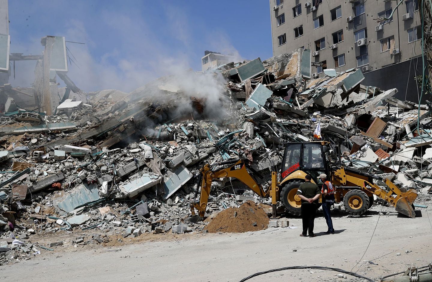 以巴冲突：以色列军队炸毁加沙一栋大楼。图为5月16日，工人清理瓦砾堆。这栋大楼是数家国际传媒的办公室所在地。（AP）