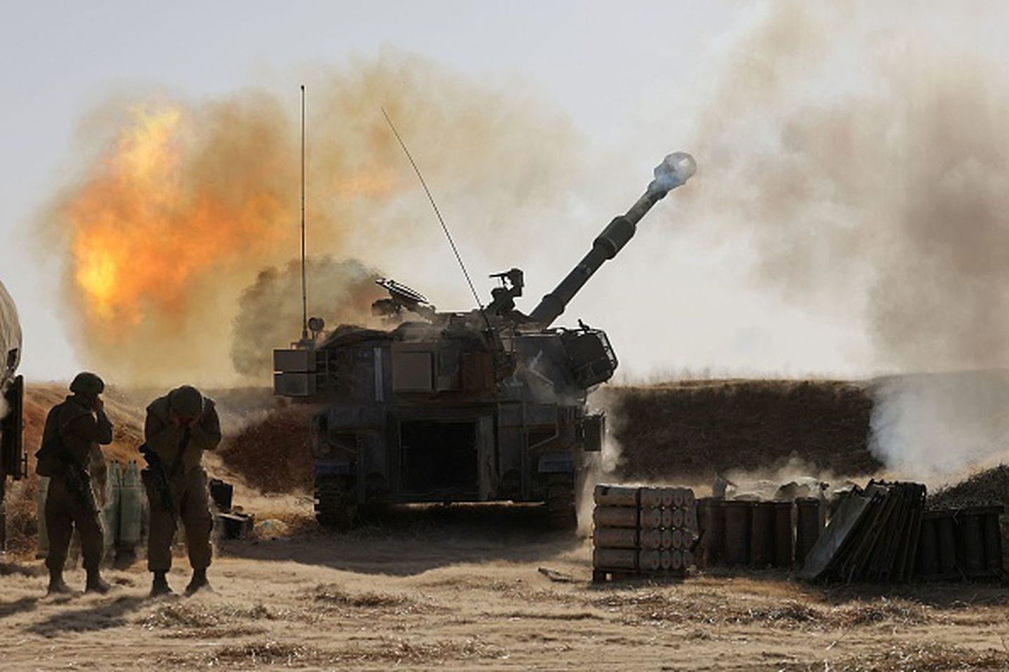 2021年5月12日，以色列南部边境城市斯德洛特，以色列国防军士兵正在操作一门155毫米自行榴弹炮向加沙城内的预定目标开火。（Getty）