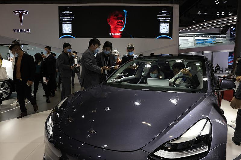 华人对特斯拉电动车很感兴趣。 图为特斯拉中国展销会，许多人前来看车。 （美联社）