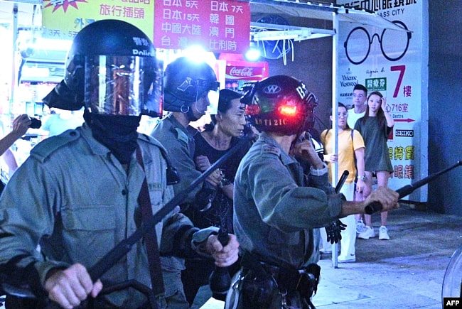 《好莱坞报道》的文章说，对于香港的暴力镇压抗议，好莱坞一直保持沉默。图为一名身份不明的男子在香港一次集会后被防暴警察带走。(2019年10月5日)