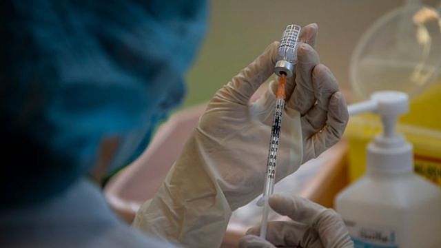 一位药剂师在一所由香港大学医学院运作的疫苗接种中心内调配上海复星—BioNTech复必泰（Comirnaty）信使核糖核酸疫苗（13/3/2021）