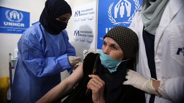 约旦马弗拉克省（Mafraq）扎塔里（Zaatari）难民营内一名年迈叙利亚难民老妇接受联合国难民署人员注射新冠疫苗（16/2/2021）