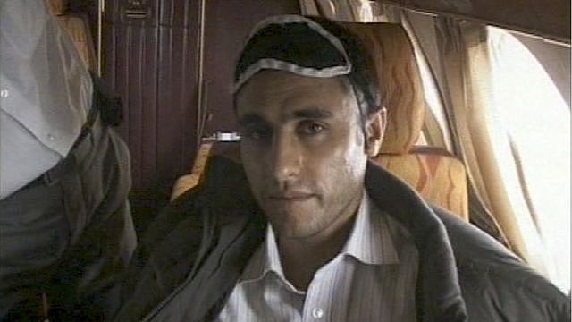 This frame grab released February 23, 2010 from Iranian state TV shows Sunni Muslim rebel leader Abdolmalek Rigi under armed guard following his arrest. Rigi is on board a small plane.