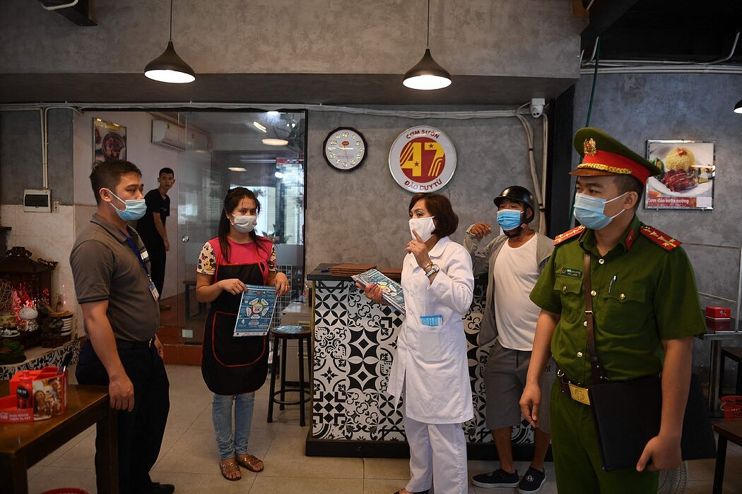 今年5月，越南河内的卫生和地方官员正在检查一家餐馆。随着新一波新冠感染，伴随而来的恐惧浪潮席卷了全国。