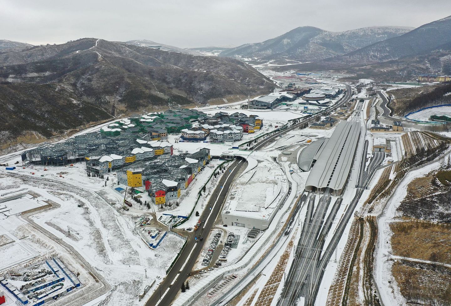 2021年2月28日，无人机拍摄河北省张家口市崇礼区太子城冰雪小镇（左）和太子城高铁站。（新华社）