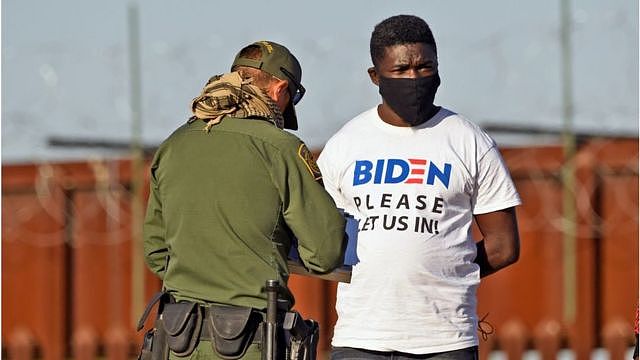 A man detained in Arizona wears a t-shirt saying 