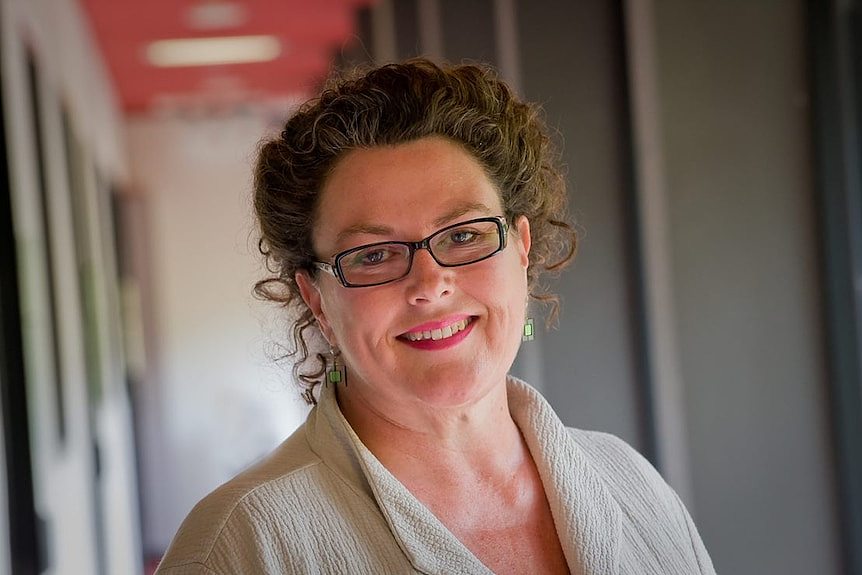 Portrait of a woman smiling at the camera with an out of focus background