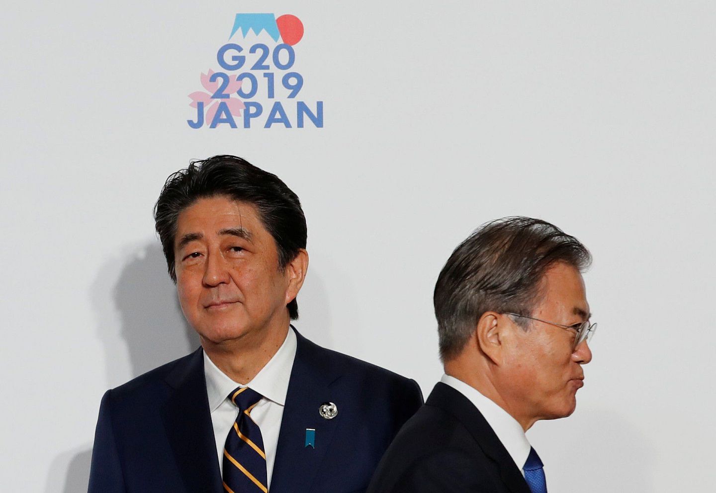 日韩关系自2018年以来转冷，图为日本时任首相安倍与文在寅在2019年G20峰会上的尴尬擦肩而过。（路透社）