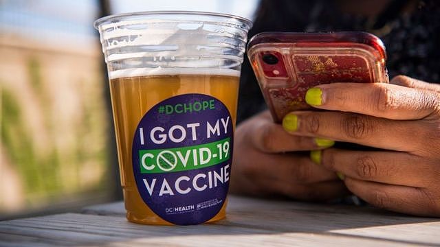 美国华盛顿某疫苗接种中心外一位接种完毕的女士在享用免费派发的啤酒（6/5/2021）