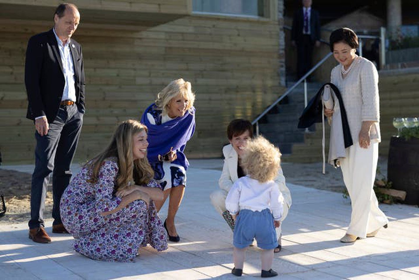 由英国首相府发布摄影师道森所拍的照片中，英国首相约翰逊之子威尔弗雷德实在魅力没法挡，逗得几位国家首脑夫人笑逐颜开。照片在2021年6月12日拍摄，当时约翰逊在第二天会议结束后的傍晚，在卡斯比湾招待与会国领袖及夫人参加烧烤聚会。（英国首相府）