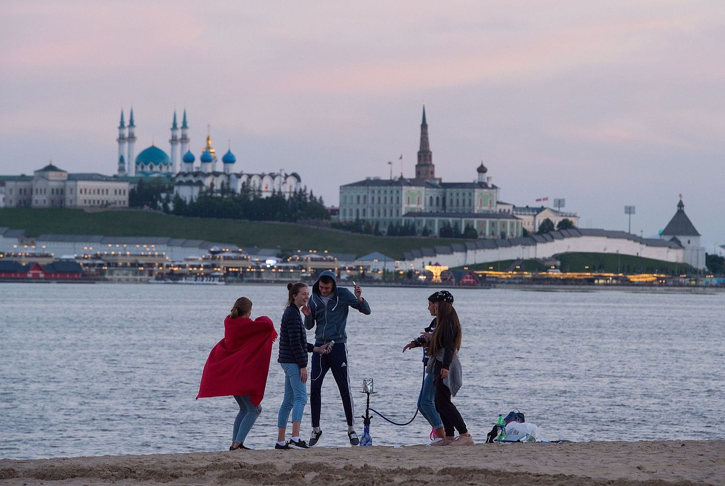 几个年轻人在伏尔加河边玩乐，河的对岸就是喀山市克里姆林宫。（Getty）