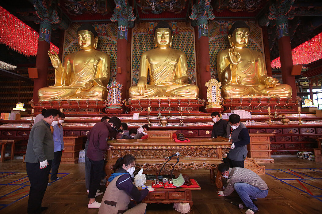 上个月首尔一座寺庙清扫活动中的佛教徒们。因为边境限制、公众遵守规则和广泛的检测，韩国的感染率和死亡率一直保持在相对较低的水平。