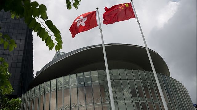 A Chinese national flag (R) and a Hong Kong national flag (L) fly outside the Legislative Council complex in Hong Kong, China, 15 July 2016
