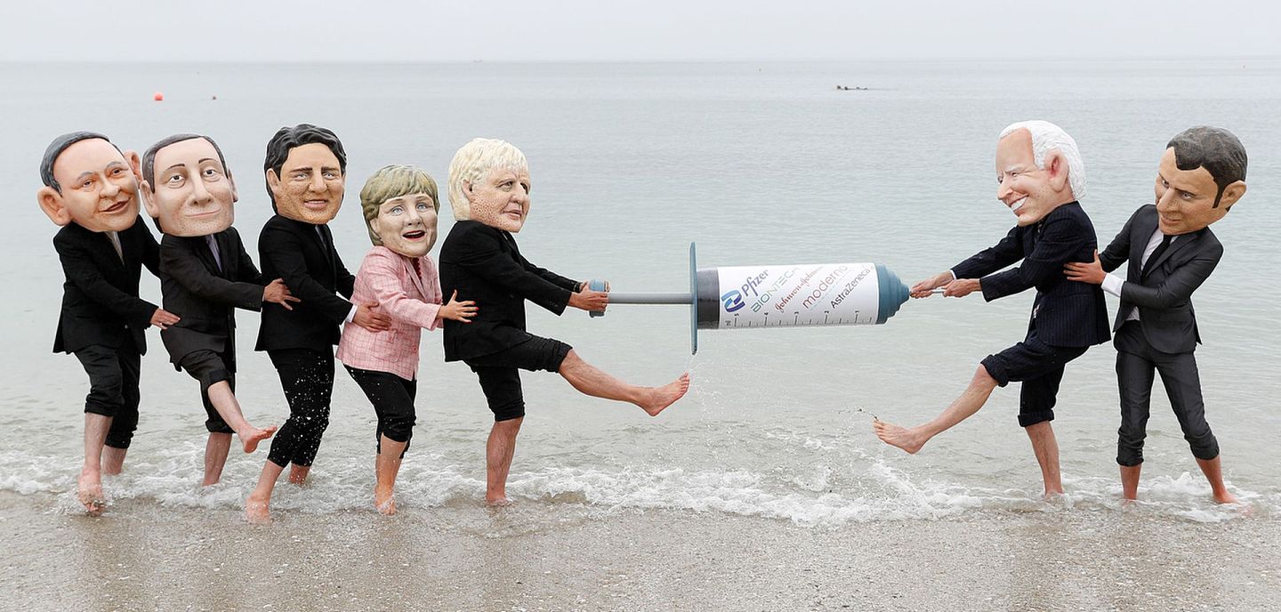 6月11日，英國康沃爾郡，樂施會成員戴上G7成員國領袖的面具，在海灘爭奪一支新冠疫苗。（Peter Nicholls／路透社）