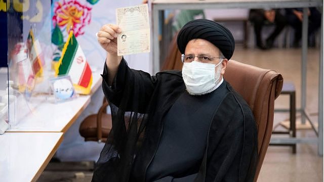 Ebrahim Raisi holds up his documents while registering as a candidate in the presidential election