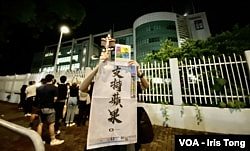 有市民高举苹果日报26周年报庆的头版广告，支持该报编采人员。 (美国之音/汤惠芸)