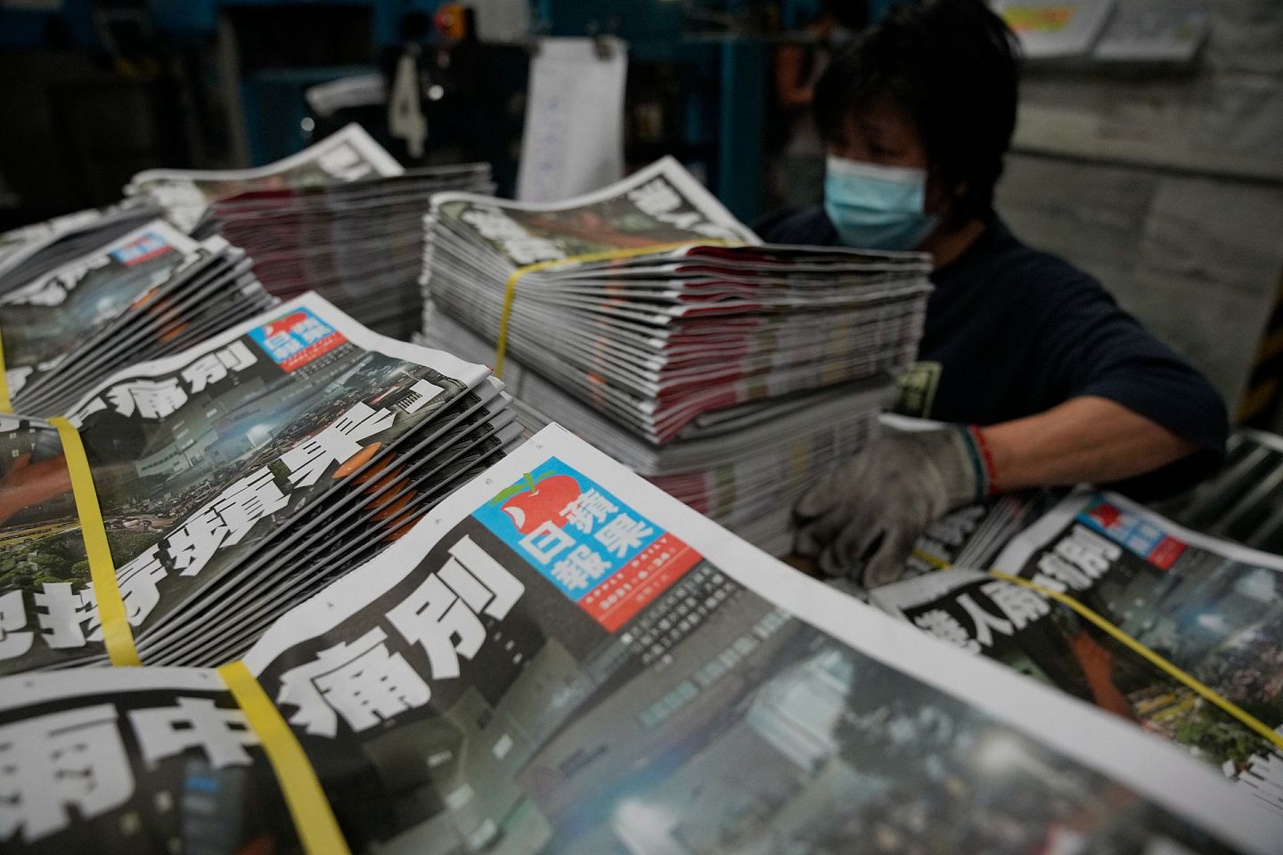 一名工人在 2021年6月24日在香港苹果日报总部的印刷厂包装《苹果日报》的副本。（AP）