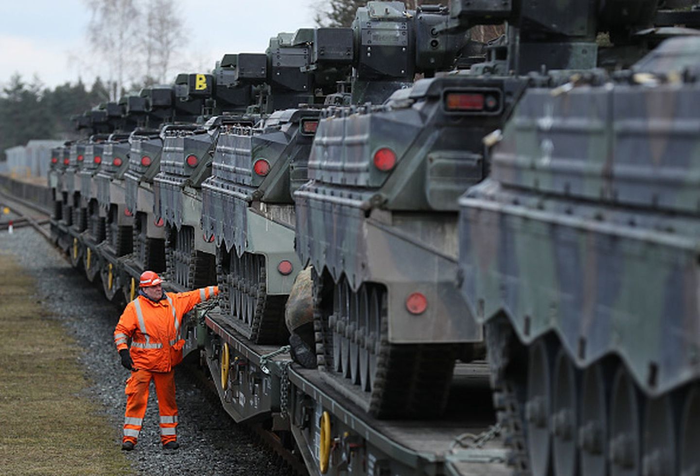 2017年2月21日，德国北部边境城市格拉芬沃尔，一名德铁工人在检验已经列装准备运往立陶宛参加北约联合军演的德国国防军马德尔轻型坦克。（Getty Images）