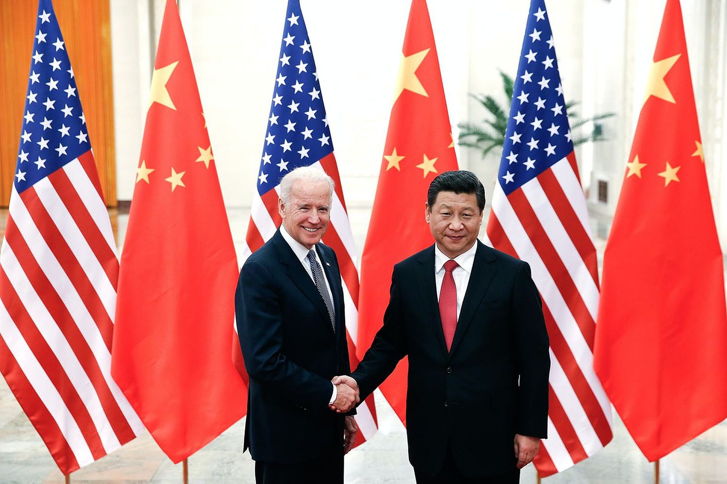 图为2013年12月4日，时任美国副总统拜登到访中国，在人民大会堂与国家主席习近平握手。（Getty）