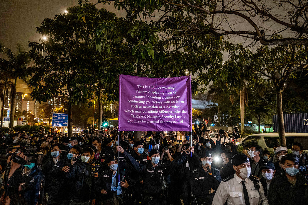 今年3月，在抗议者为支持被逮捕的亲民主活动人士举行的集会上，警察举着说明什么是违反国安法行为的警告牌。