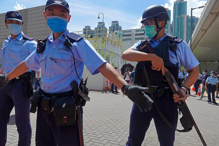香港警察戴着口罩站在一边。