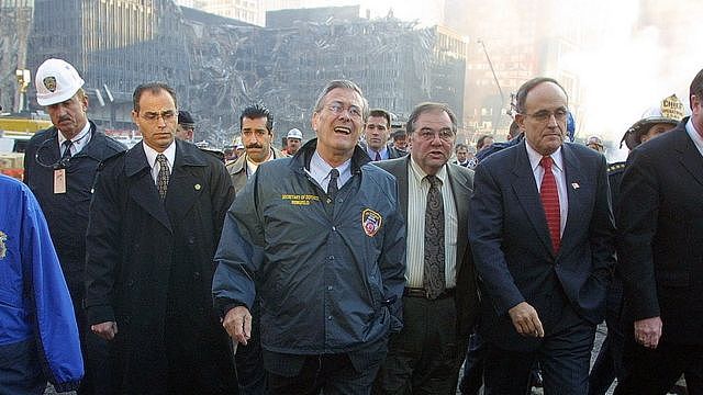 2001年11月，拉姆斯菲尔德(中)和前纽约市长鲁迪·朱利安尼(右)一起游览世贸遗址。