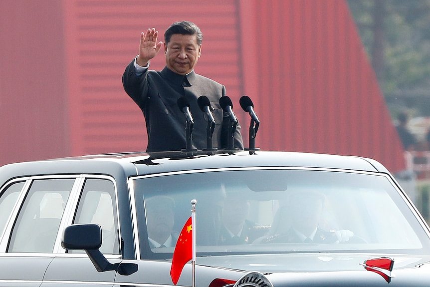 Chinese President Xi Jinping waves from the sunroof of a car as he addresses a military parade in China.