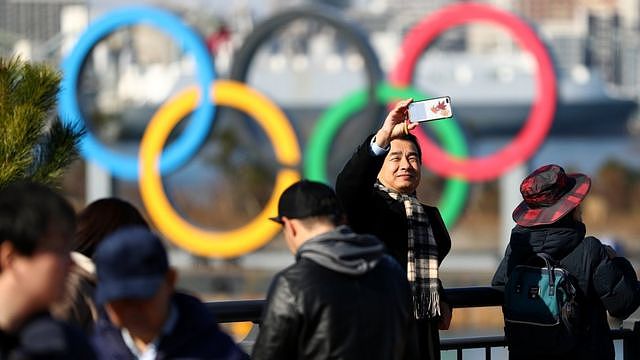 Members of the public get pictures near the Olympic rings on Tokyo