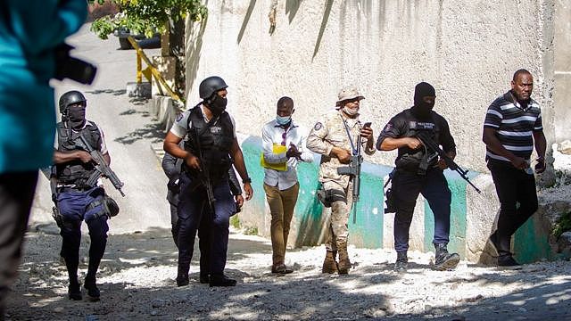 海地太子港佩蒂翁维尔市镇总统莫伊兹私宅外手持轻机枪的警员巡视四周（7/7/2021）
