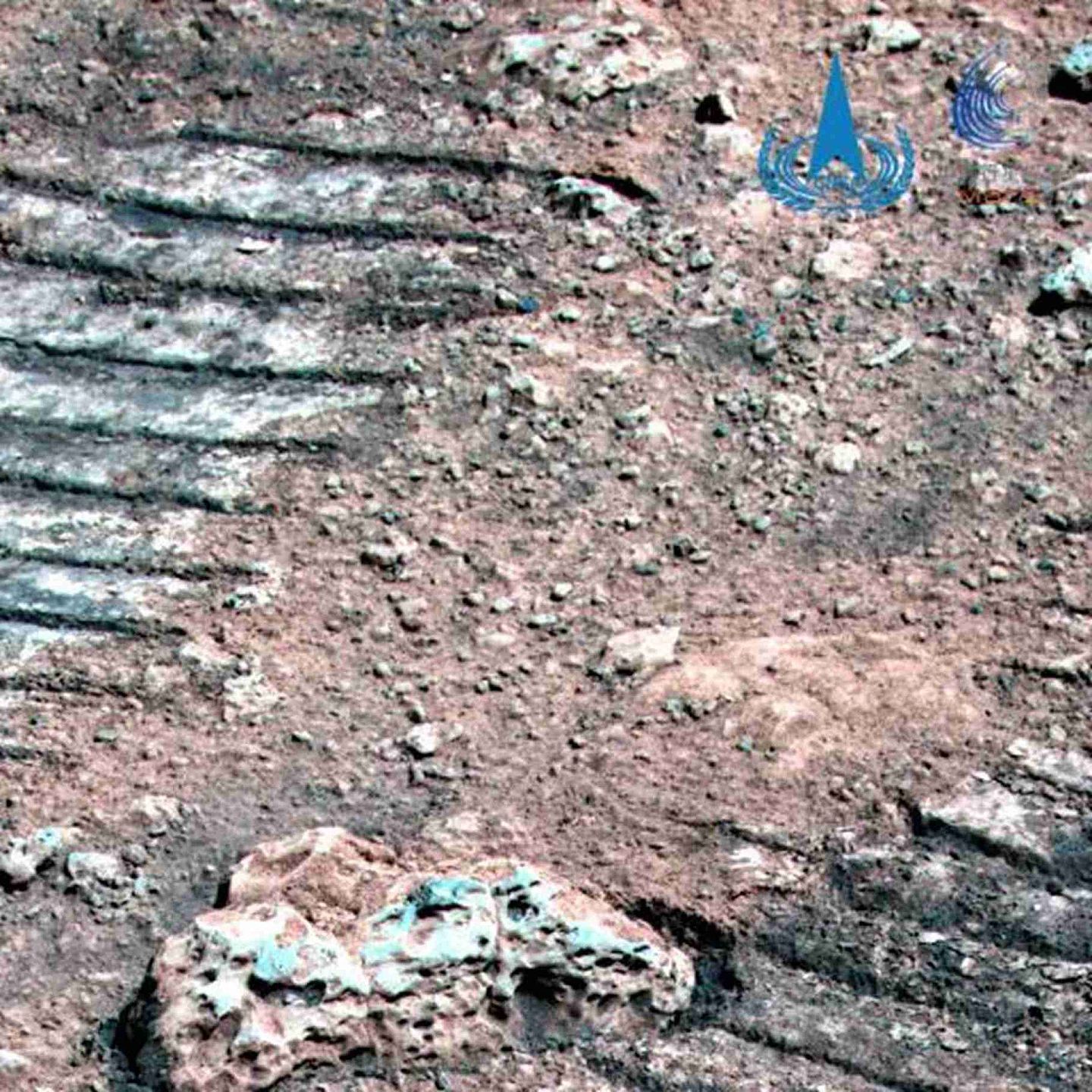 这是由“祝融号”火星车拍摄的火星岩石，图中可见火星岩石纹理和火星车车辙。（微信@中国探月工程）