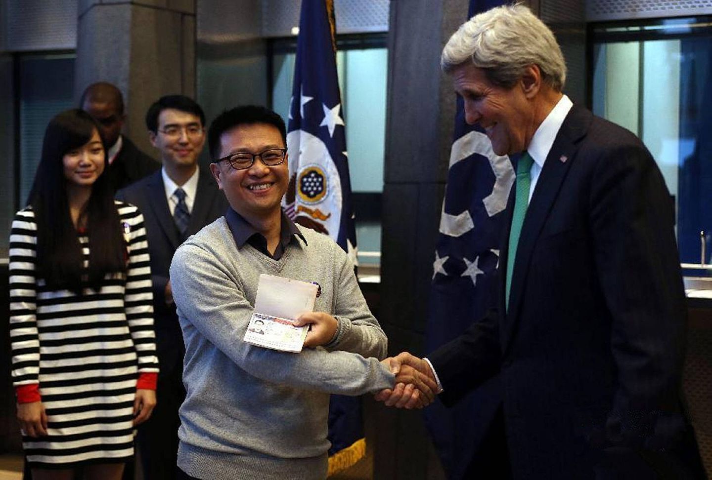 2014年11月12日，在美国驻华大使馆签证处，美国时任国务卿克里（John Kerry，右一）为首批获得最长10年美国签证的中国申请人颁发新签证。（新华社）