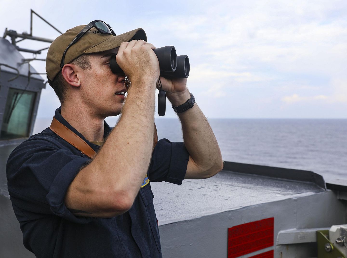 军舰上的工作人员用望远镜瞭望远方。（第7舰队官网）