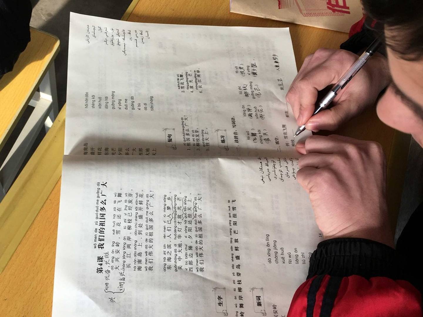 在记者被允许参观的一堂课上，一位维吾尔族民众学习汉语，书写汉字。（Reuters）